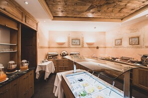 Montaje de bufé con diferentes alimentos, una estación de café y una mesa para el desayuno.