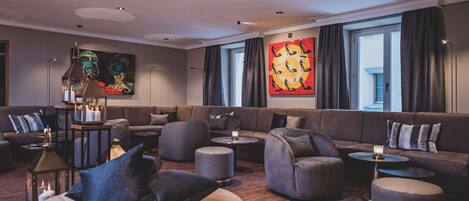 A modern lounge area with sofas, ottomans, and a coffee table.