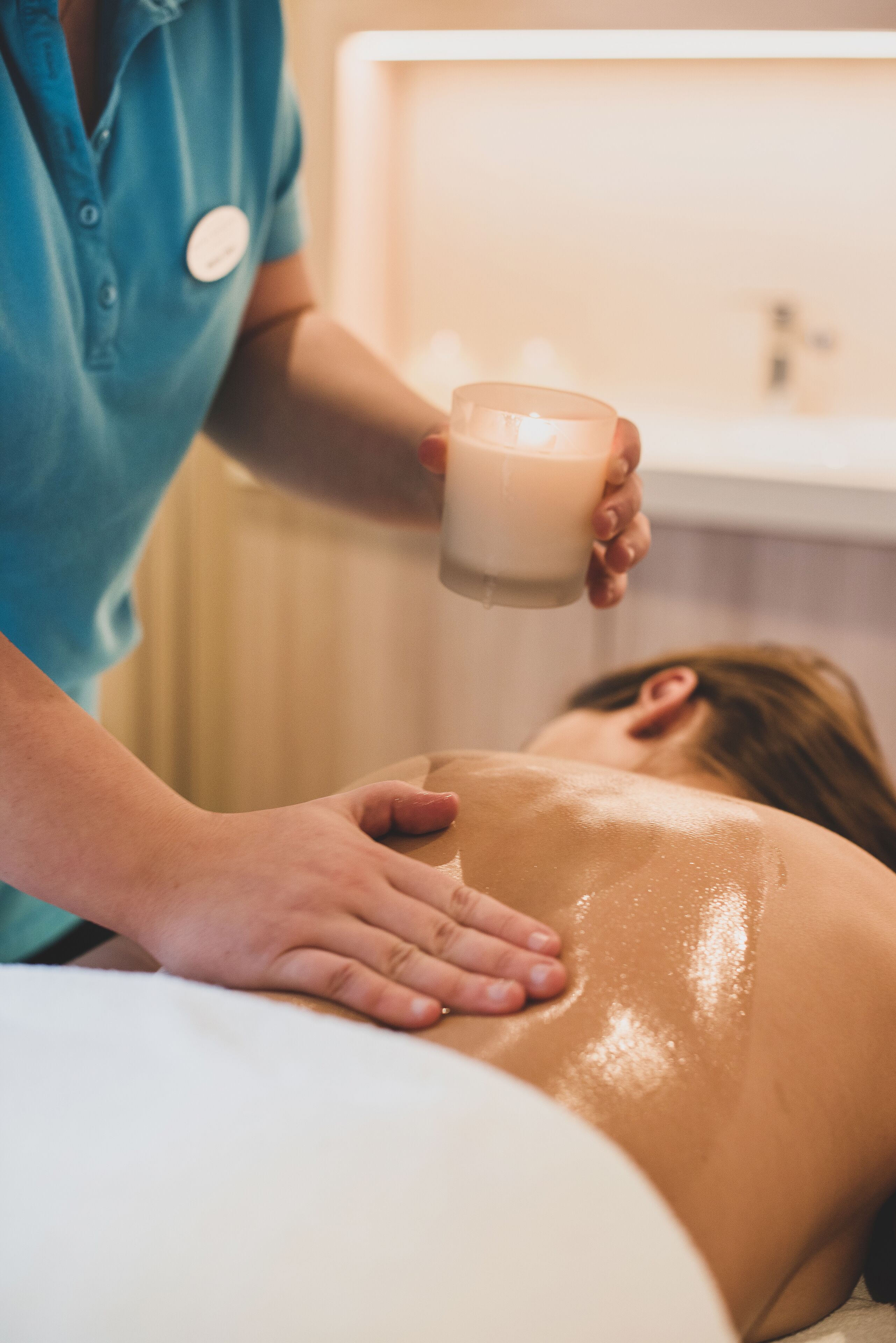 Sesión de terapia de masaje con un terapeuta sosteniendo una vela.