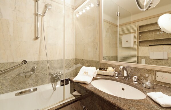 A modern bathroom with a bathtub, a sink, and a shower. - Art Boutique Hotel Monopol (St. Moritz)