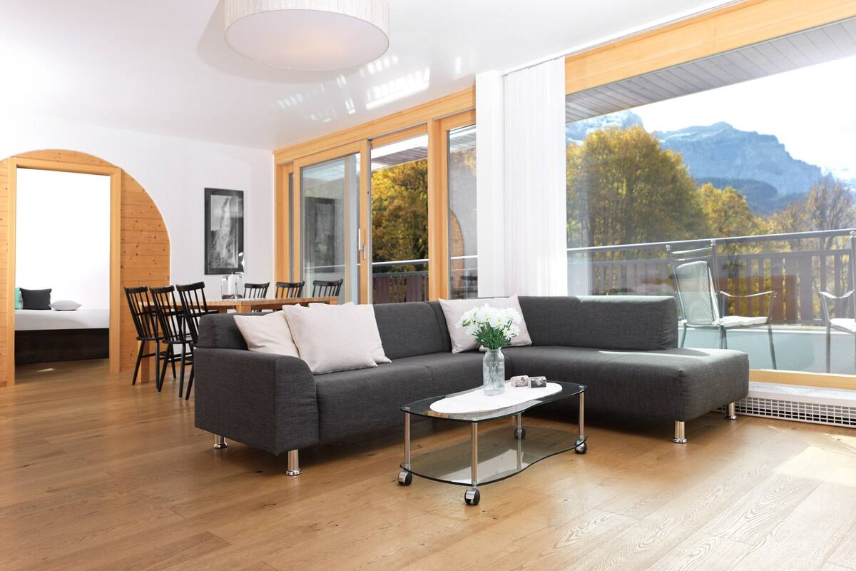 Ein modernes Wohnzimmer mit einer Couch, einem Couchtisch und einem Essbereich.