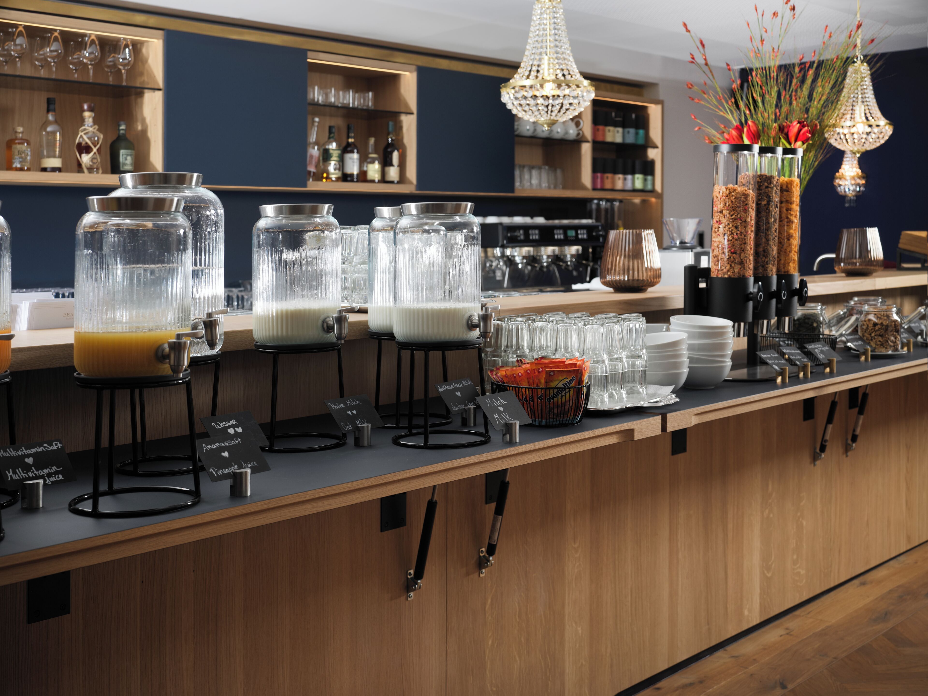 A bar area with multiple drink dispensers, a coffee machine, and a variety of glassware.
