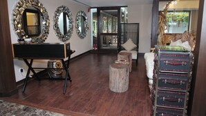 A spacious room with a piano, multiple mirrors, a wooden cabinet, and a view of an outdoor area. - Hotel Diplomat (New Delhi)