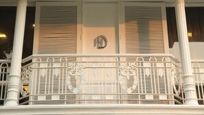 A balcony with ornate metal railings and a white column structure. - Hotel Diplomat (New Delhi)