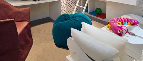 A child's bedroom with a bunk bed, a desk with a computer, and a TV.