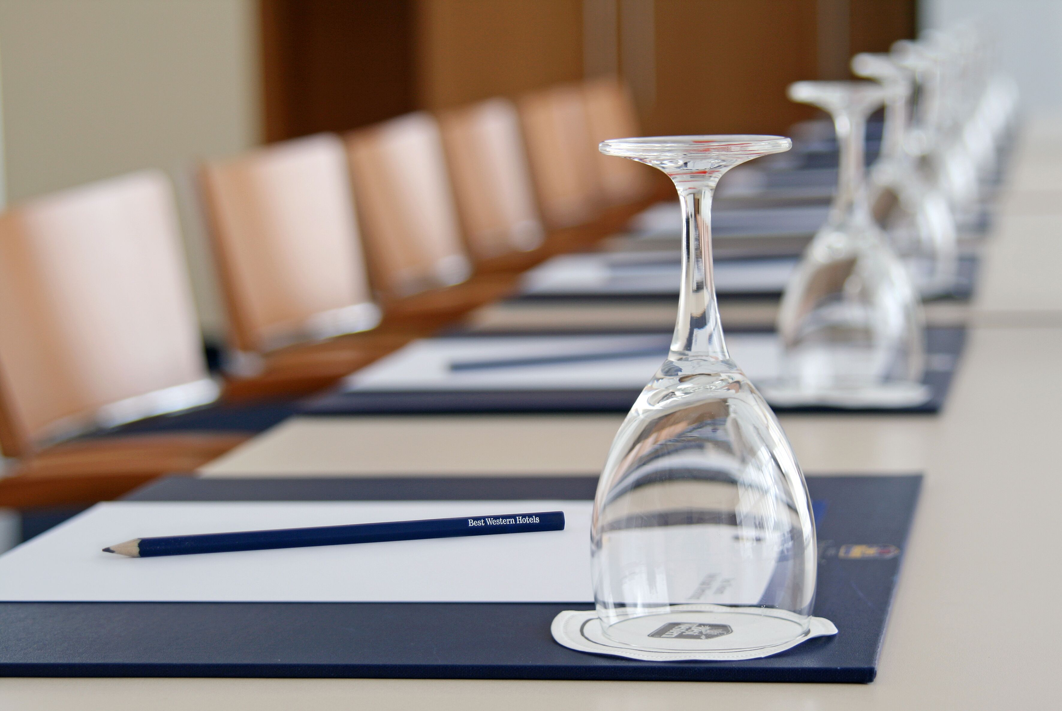 A conference table with a clear glass dome centerpiece, a nameplate, and a pencil.
