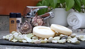 A stone surface with soap, seashells, and a towel.