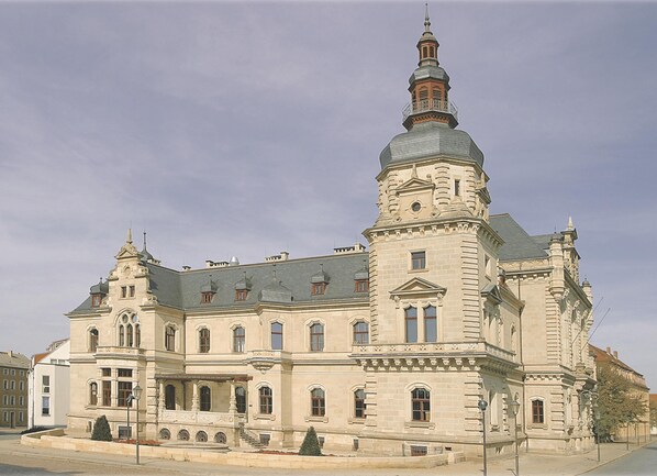 A large, historic building with a prominent tower and multiple windows.