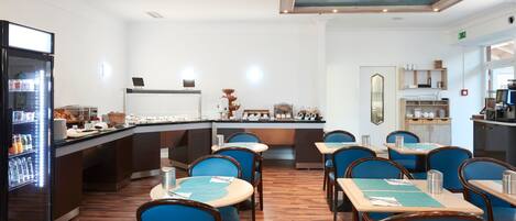 Un restaurante con barra de buffet, sillas azules y una máquina de café.
