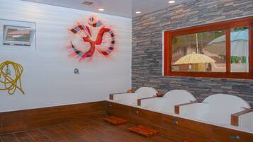 Una habitación con pared de piedra, un ventanal grande e iluminación empotrada en el techo.