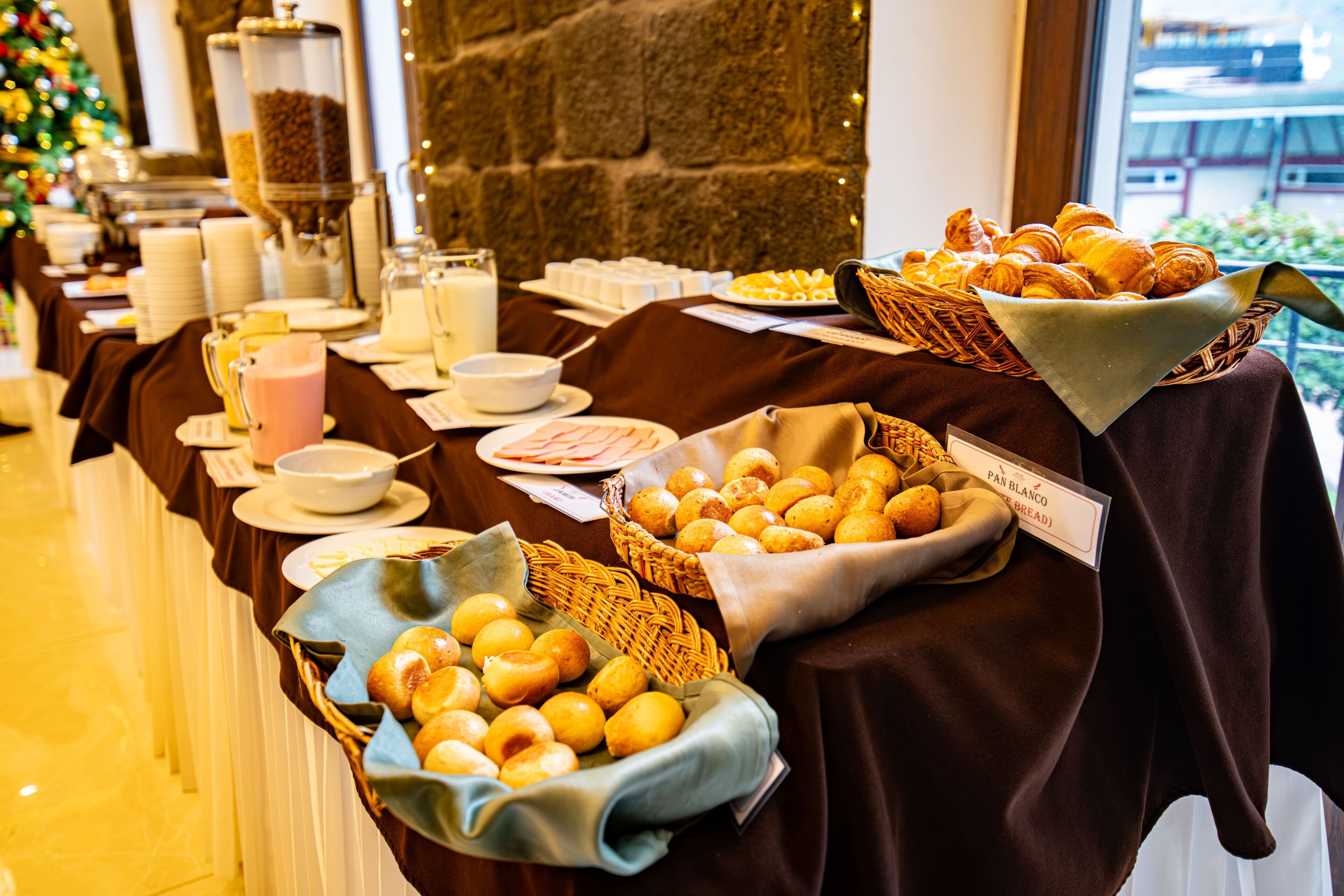 Une table de buffet proposant divers plats et une pancarte indiquant « Pain blanc ».