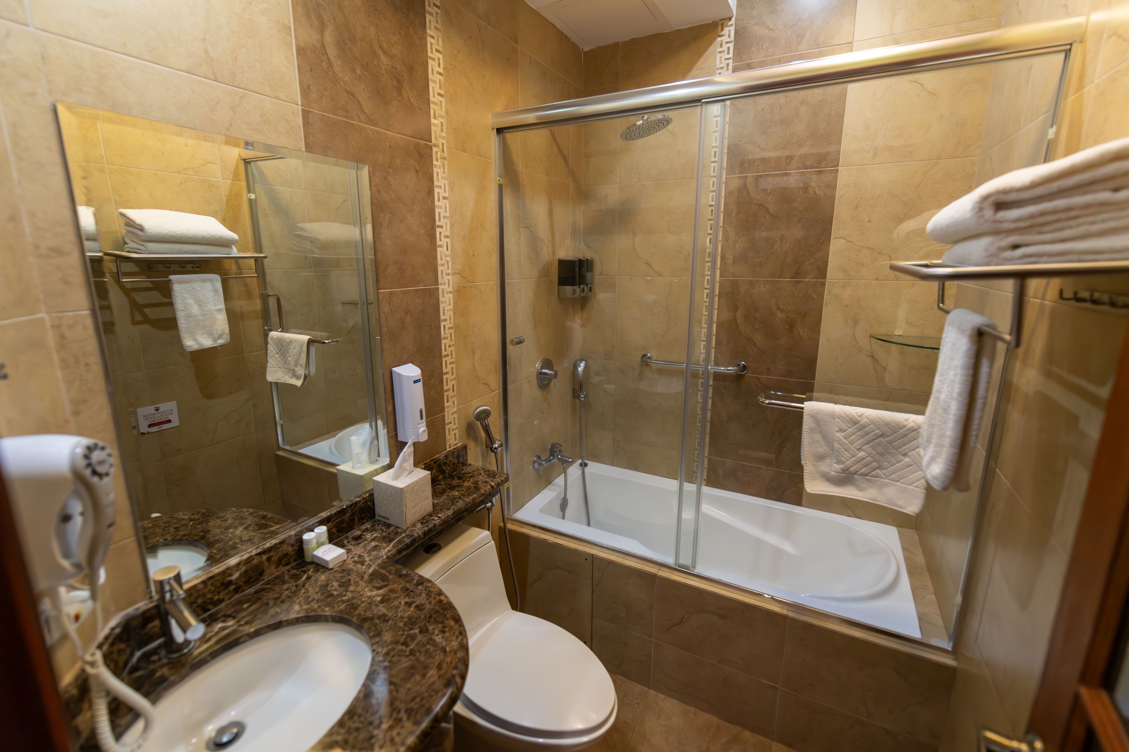 A modern bathroom with a glass-enclosed shower, a white sink, and a toilet.