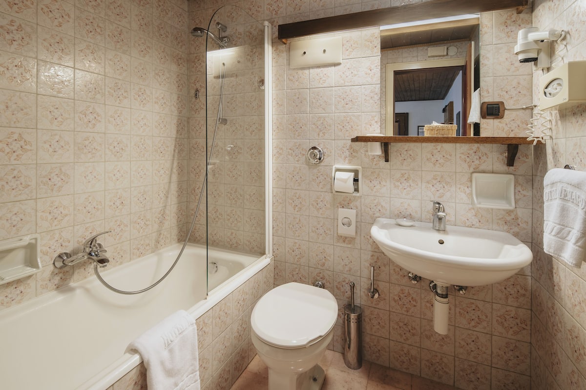 A bathroom with a bathtub, toilet, and sink.