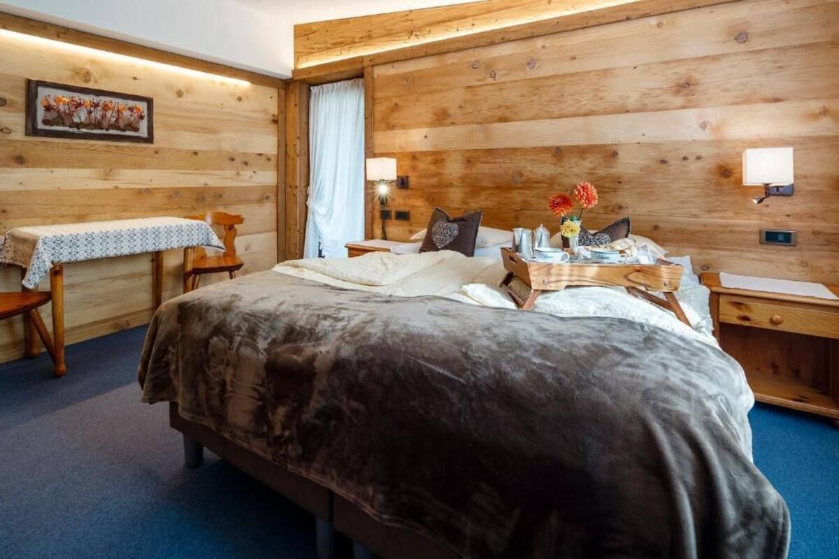 A cozy room with a large bed, a small table, and a nightstand.