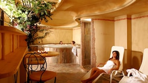 Ein Spa-Zimmer mit Whirlpool, einer Sitzecke inklusive Tisch und Stühlen sowie einer Zierpflanze.
