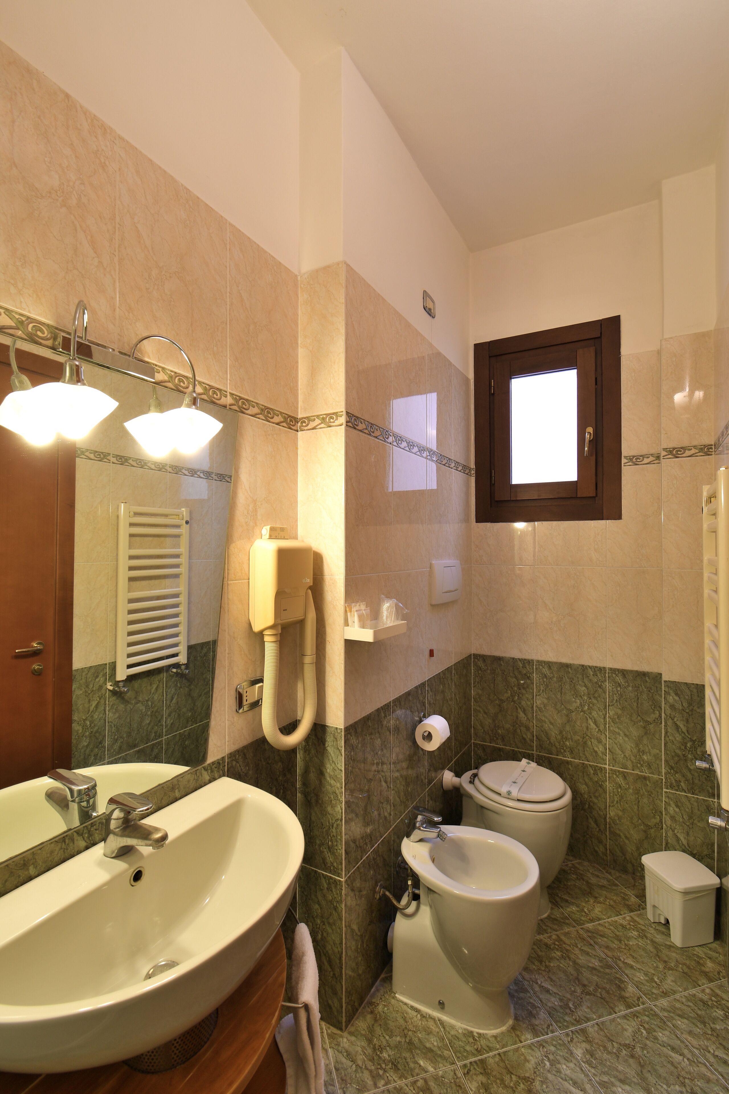 Une salle de bain équipée d’un lavabo, d’un miroir, de toilettes et d’une douche.