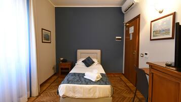 Ein Hotelzimmer mit einem Bett, einem Nachttisch und einem Schreibtisch mit Stuhl.
