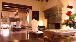 A dining area with wooden furniture and a stone fireplace. - Castello Di Petroia Relais (Gubbio)