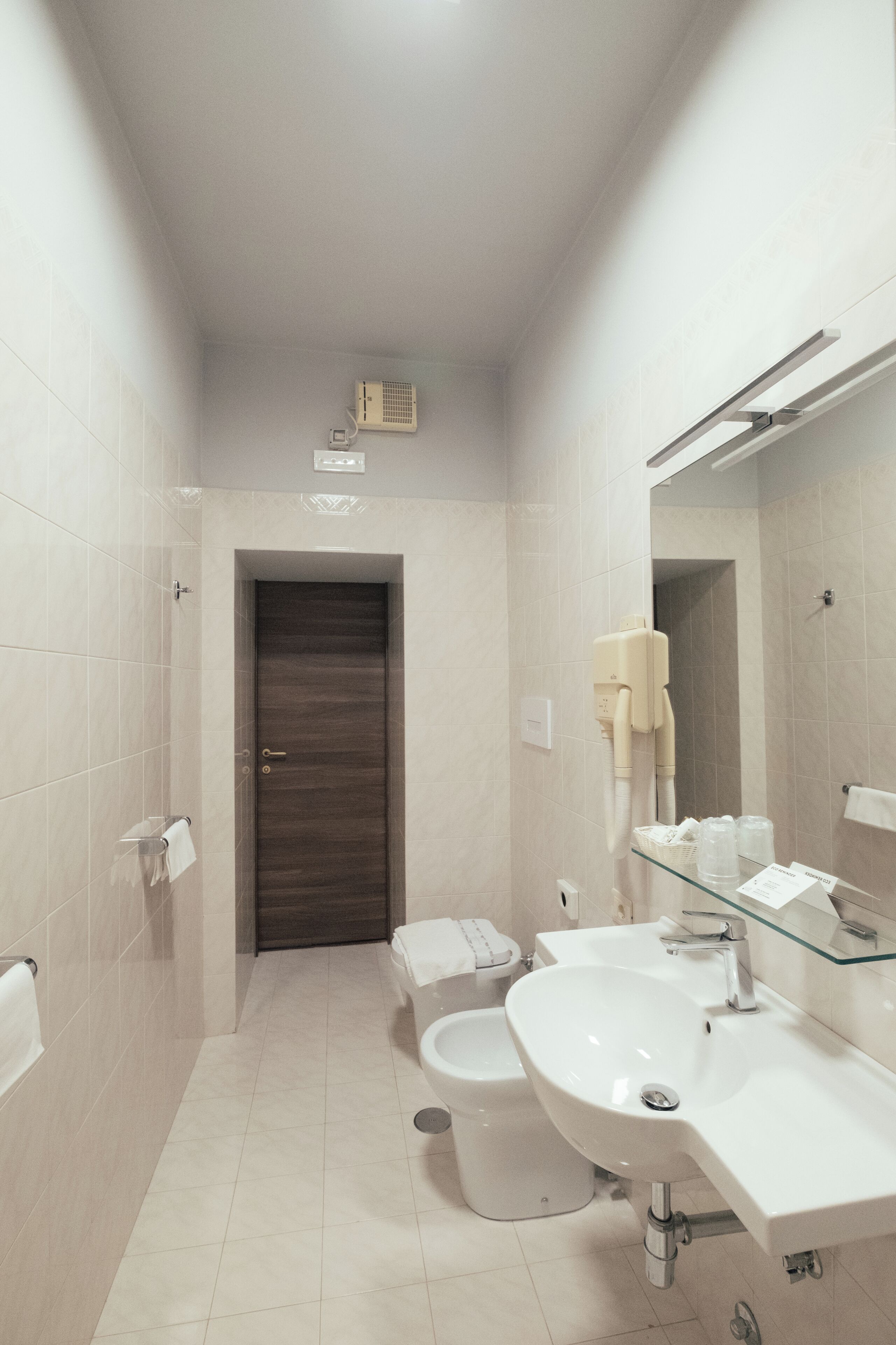 A modern bathroom with a toilet, bidet, and sink.