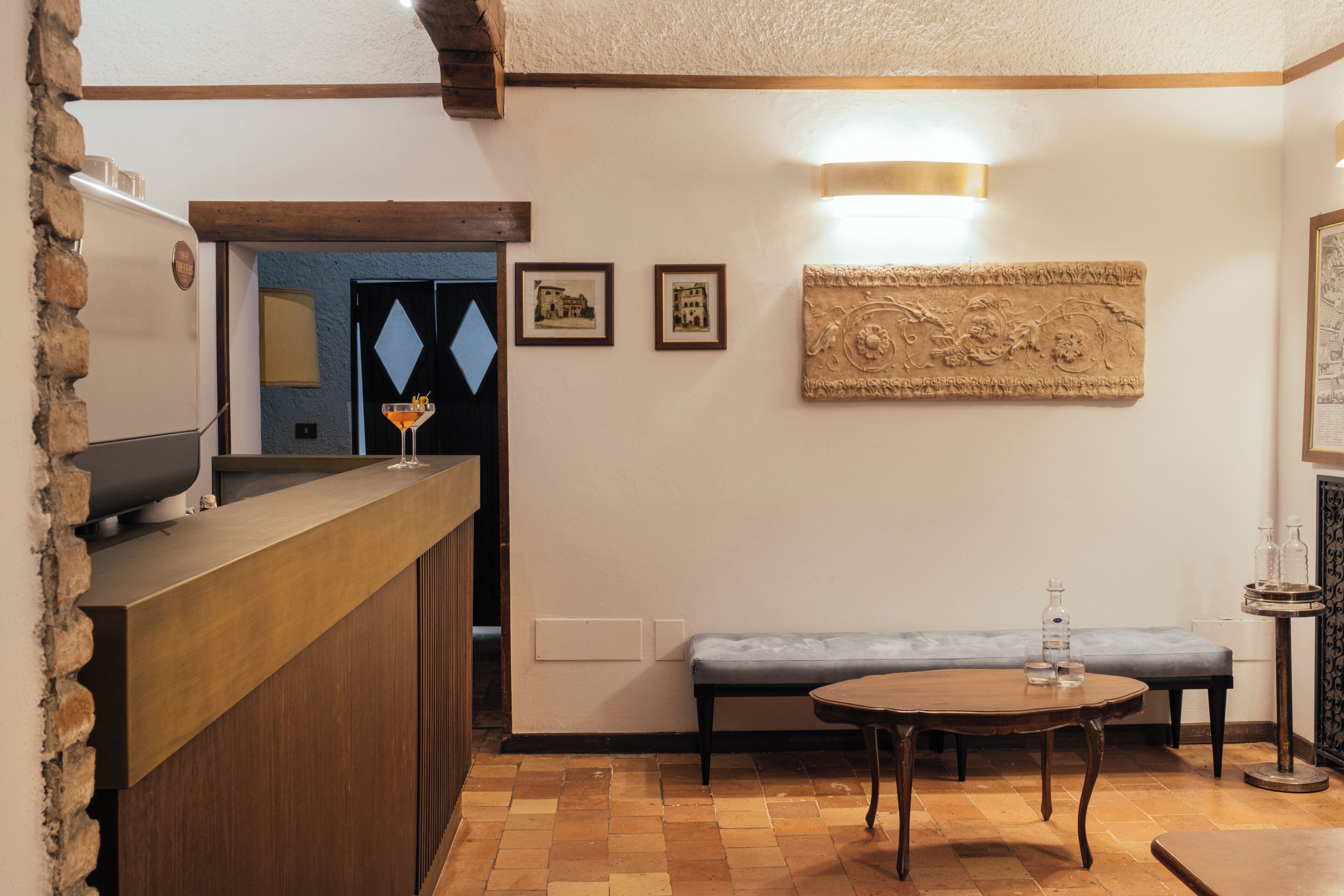 A reception area with a wooden counter, a bench, a round table, and wall-mounted artwork.