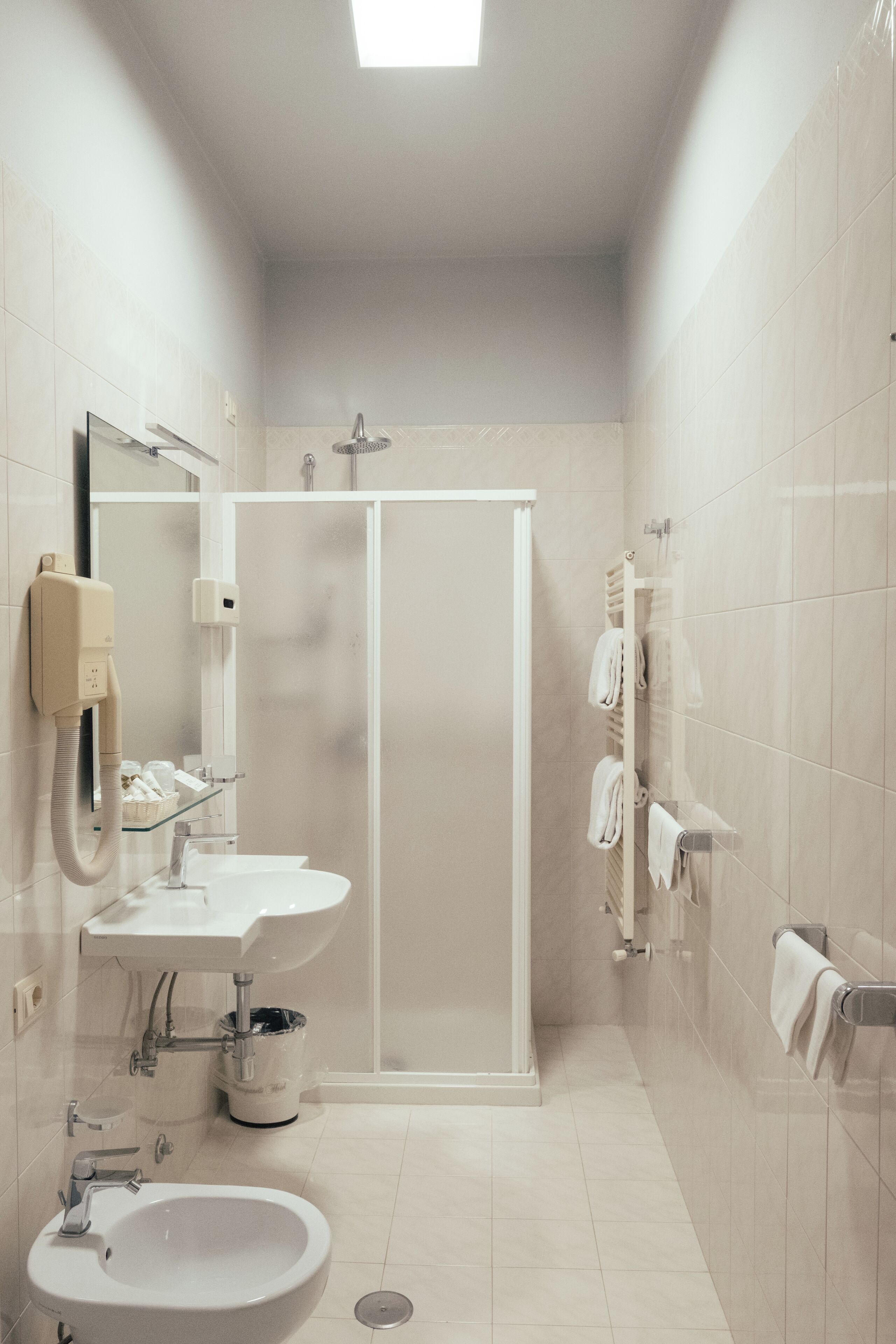 A modern bathroom with a sink, mirror, and shower.