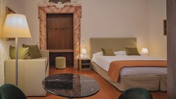 Una camera d'albergo con un letto, un divano, un tavolo e una lampada.