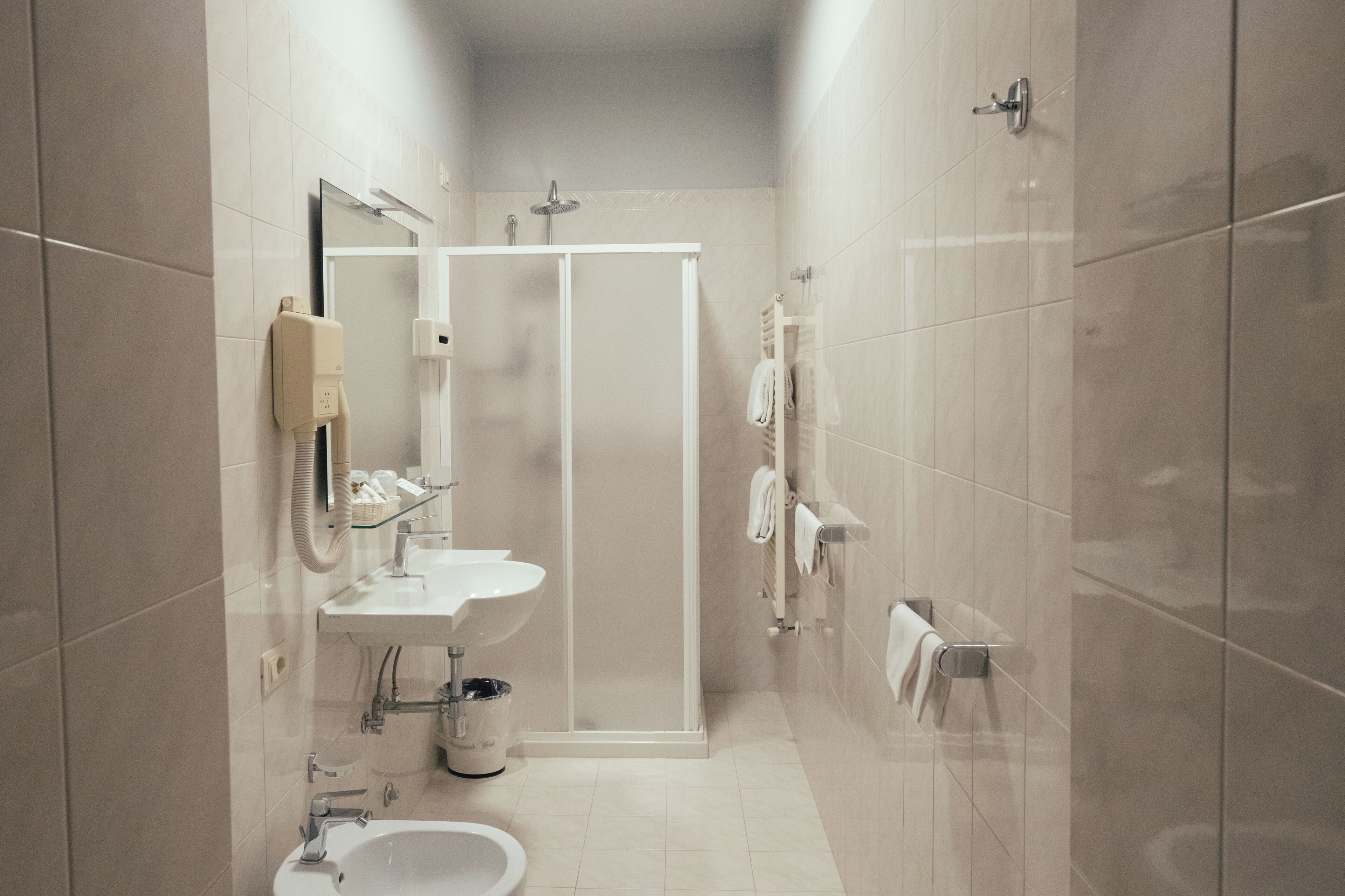 A modern bathroom with a shower enclosure, a sink, and a toilet.