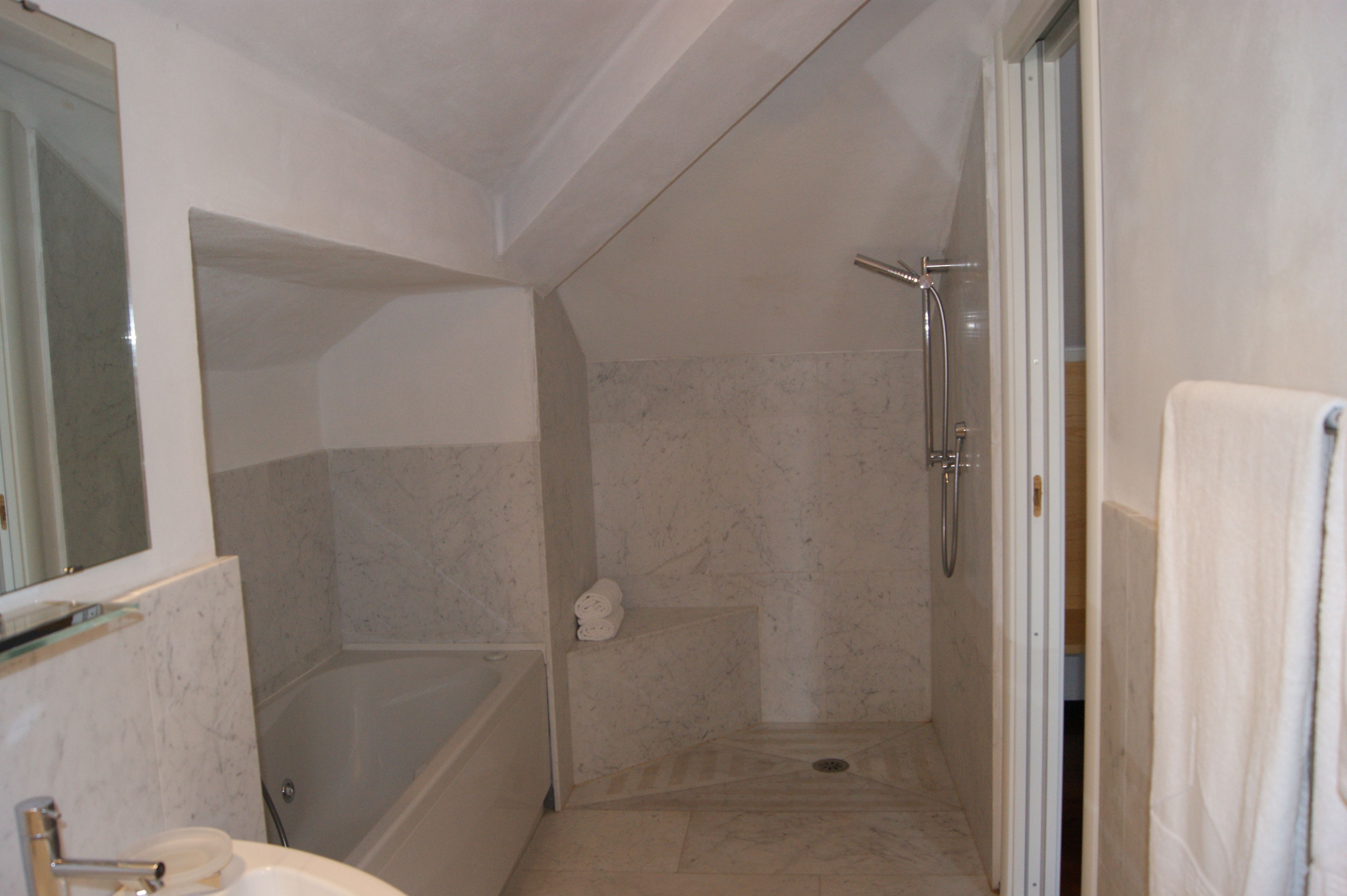 Une salle de bain avec une douche, une baignoire et un lavabo.