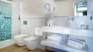 A modern bathroom with a glass shower enclosure, a white sink, and a vanity with toiletries.
