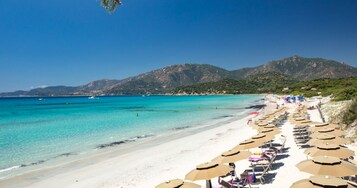 Playa privada, arena blanca, sillas reclinables de playa, sombrillas