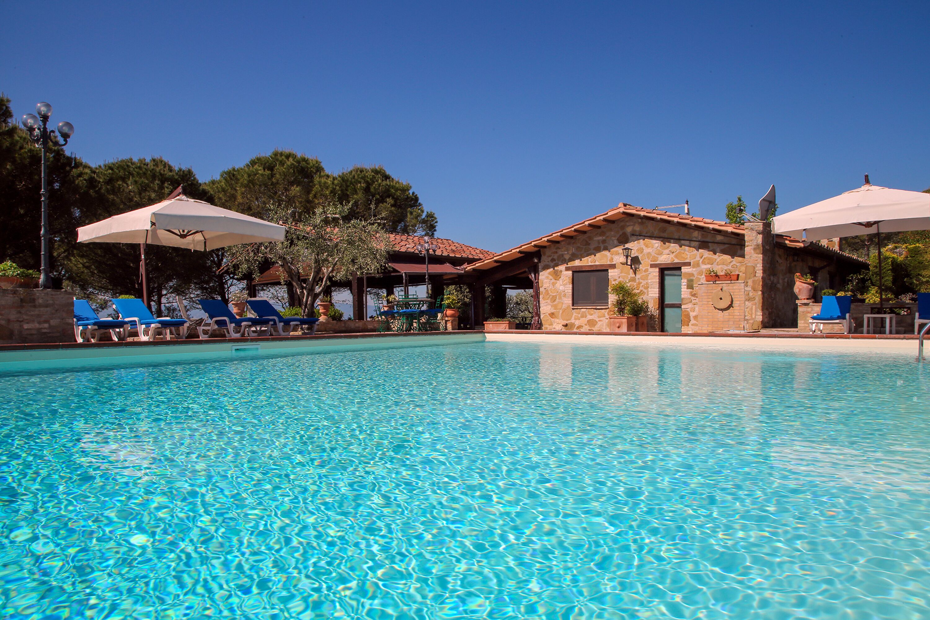 Een seizoensgebonden buitenzwembad, parasols voor strand/zwembad