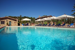Una piscina al aire libre de temporada, sombrillas