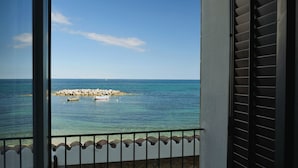 A balcony with a view of the sea, a rocky outcrop, and a few boats. - Hotel Tonnara (Trabia)