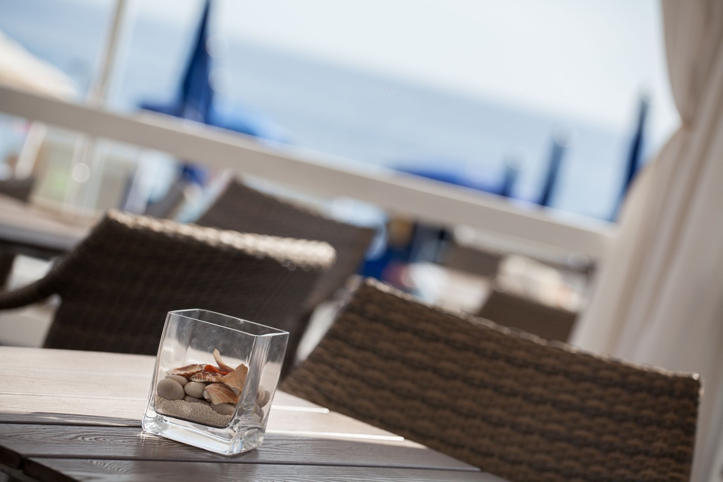A glass table with a decorative arrangement of stones and shells.