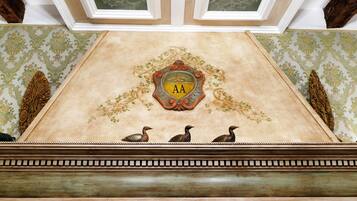 A ceiling with a decorative emblem featuring the letters "AA" and three ducks.