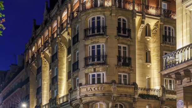 Ein historisches Gebäude mit mehreren Balkonen und einem Schild mit der Aufschrift 'LA CAFE'.