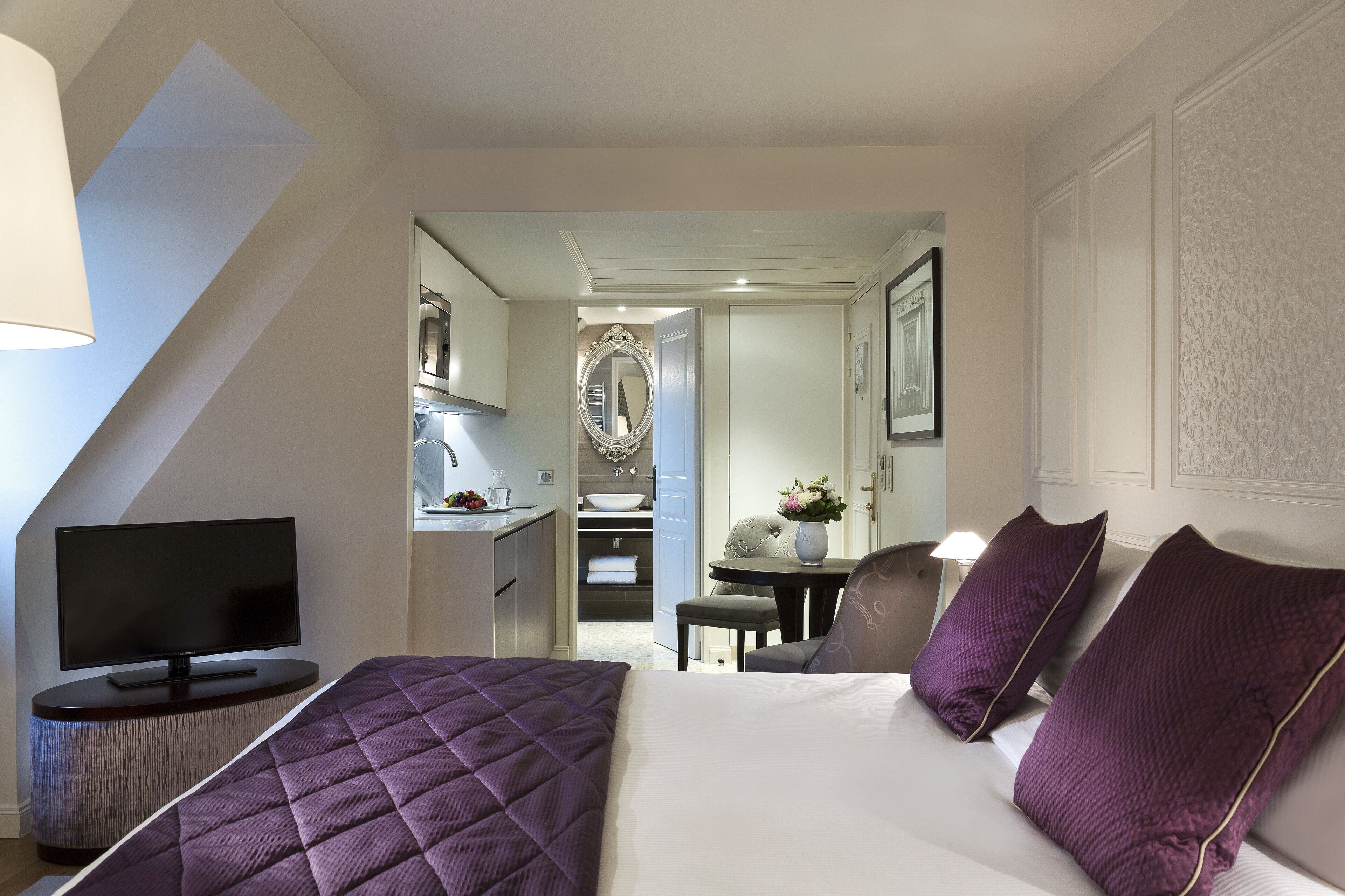 Una habitación de hotel con cama, televisión, escritorio y silla.