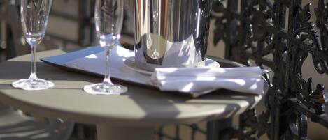 A table with a metal bucket, two wine glasses, and a napkin.