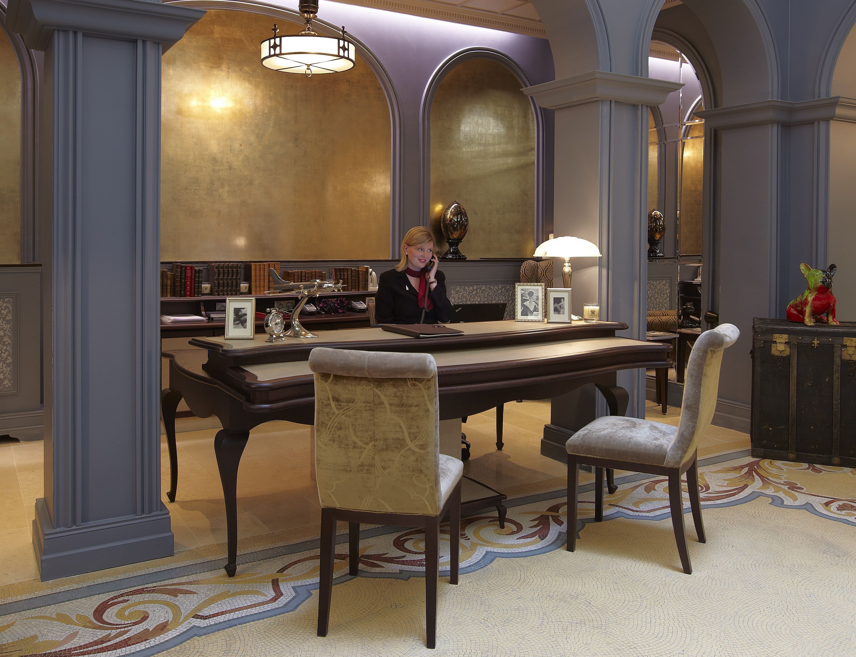 Une bibliothèque avec des étagères, un bureau et des chaises.