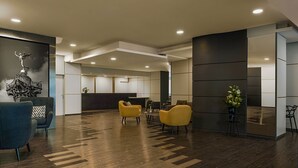 Una hall moderna con pavimento in legno, una reception e zone relax.