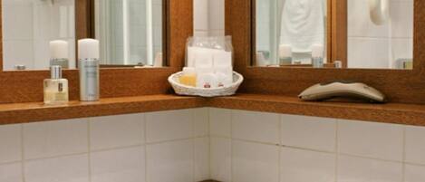 A bathroom with a large mirror, a sink, and toiletries on the countertop.