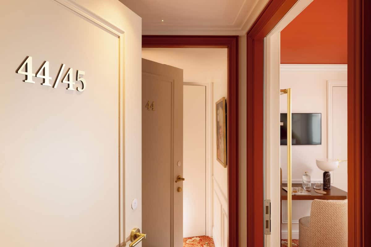 A hotel corridor with a door labeled '44/45'.