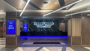A hotel reception area with a 'Hollywood Casino Hotel' sign, a 'PENN PLAY' sign, and a 'HOTEL CHECK-IN' sign. - Hollywood Casino Gulf Coast (Bay St Louis)