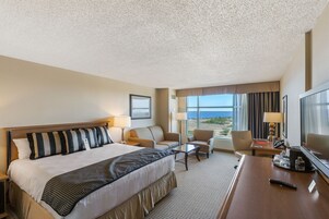 Una habitación de hotel con una cama grande, un sofá, un escritorio y un televisor.