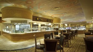 A restaurant area with a curved counter, multiple seating arrangements, and a ceiling with a floral design. - Hollywood Casino Gulf Coast (Bay St Louis)