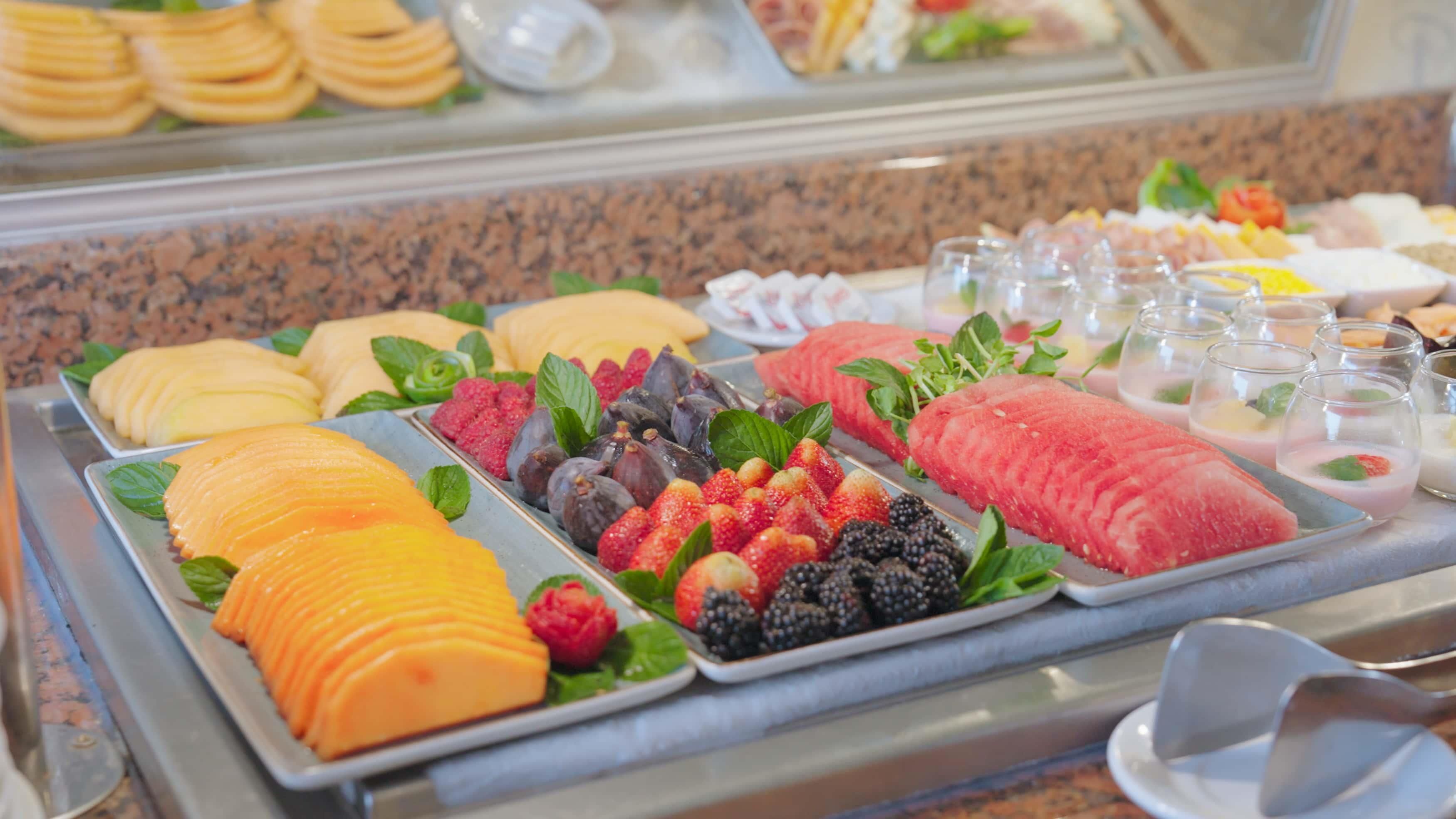 A buffet with various fruits and desserts.