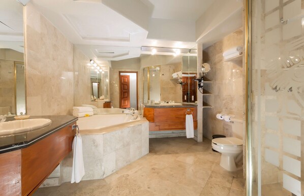 A modern bathroom with a large bathtub, a separate shower area, and a toilet.