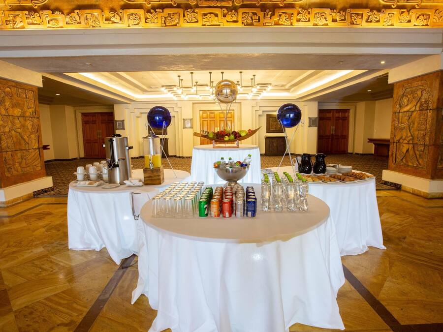 Ein Festsaal mit gedeckten Tischen für ein Buffet, mit einer Auswahl an Speisen und Getränken.