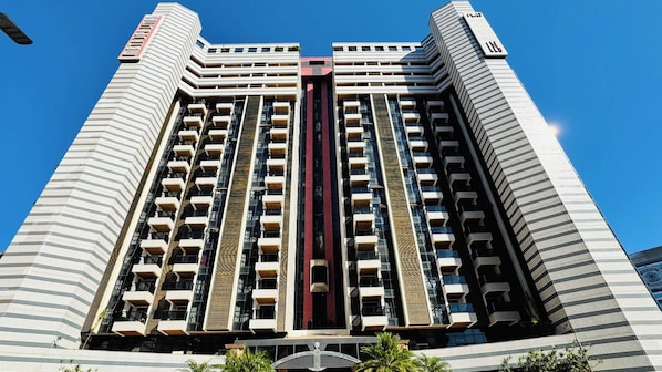 Un immeuble de grande hauteur doté de nombreux balcons et d’un élément vertical central.