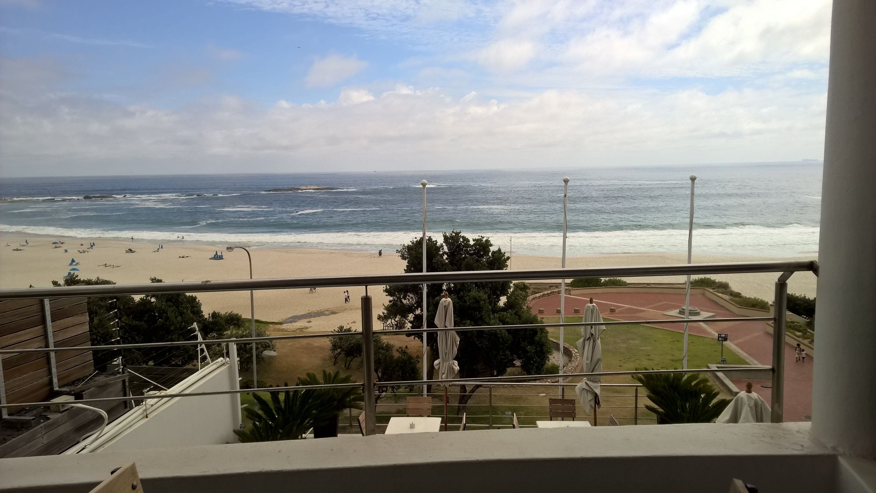 Un balcón con vista a una playa y al océano.